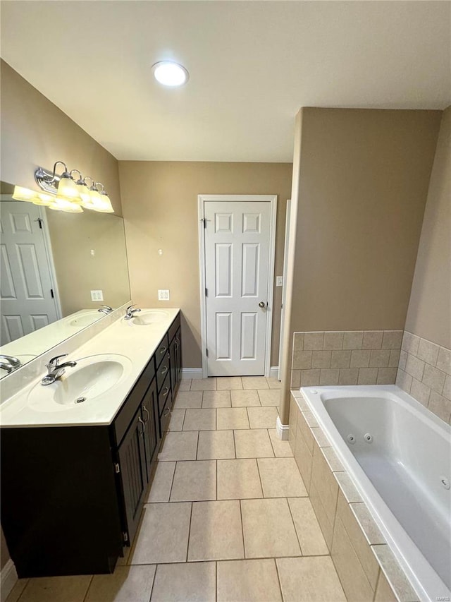 bathroom with tiled tub, vanity, and tile patterned flooring