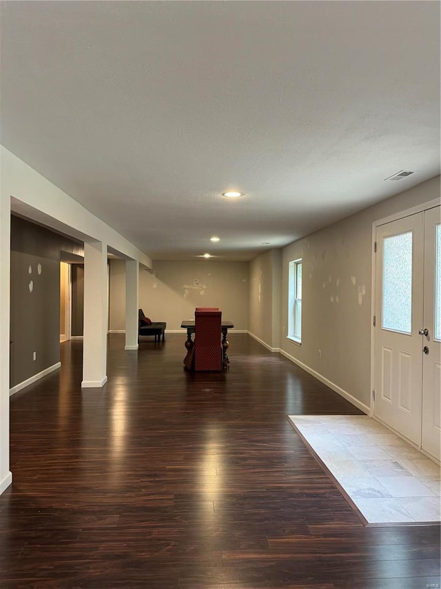 unfurnished living room featuring french doors and dark wood-type flooring