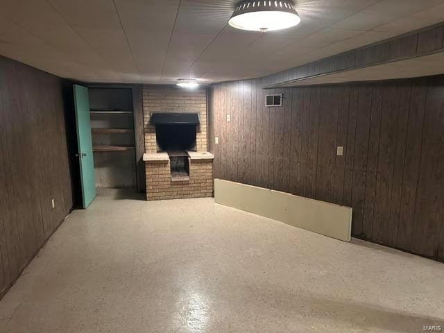 basement featuring wood walls