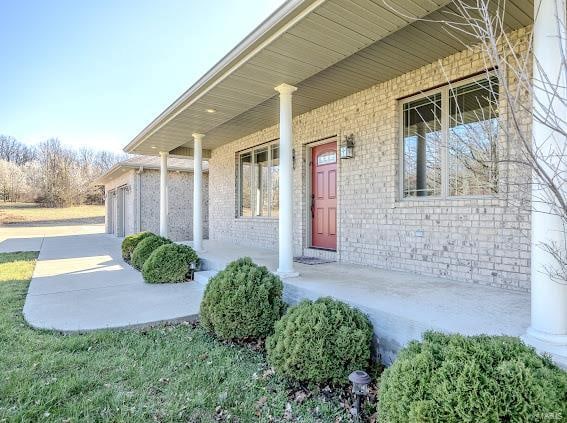 entrance to property featuring a porch and a garage