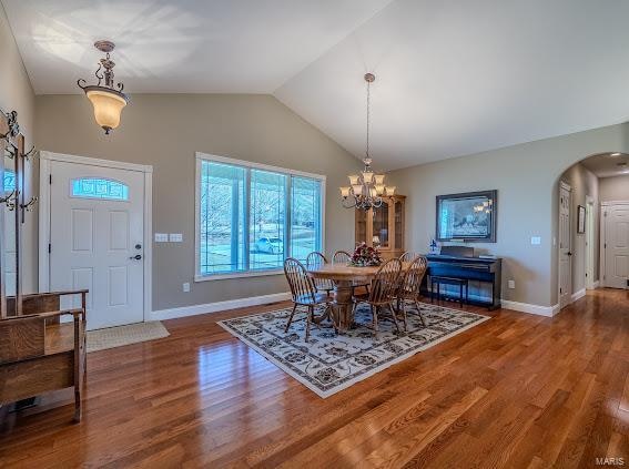 dining room featuring an inviting chandelier, lofted ceiling, and hardwood / wood-style floors