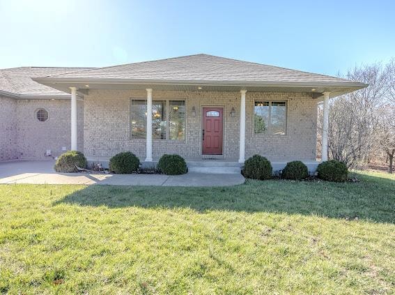 view of front of property featuring a front lawn and covered porch