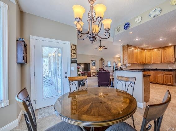 dining space featuring ceiling fan with notable chandelier