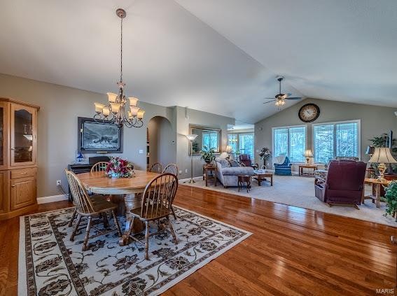 dining space featuring ceiling fan, hardwood / wood-style flooring, and vaulted ceiling