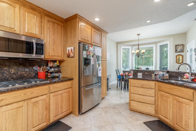 kitchen featuring hanging light fixtures, sink, stainless steel appliances, an inviting chandelier, and decorative backsplash