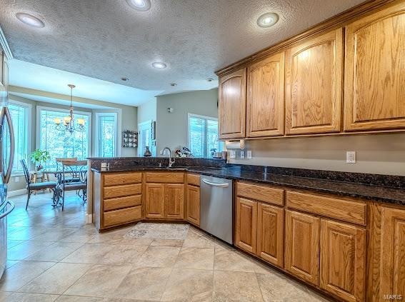 kitchen featuring pendant lighting, dishwasher, vaulted ceiling, and plenty of natural light