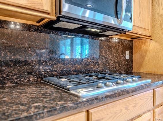 details with light brown cabinetry, stainless steel appliances, and tasteful backsplash