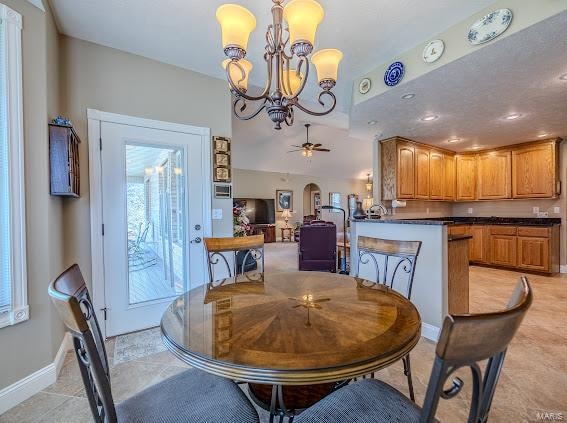 dining space featuring light tile patterned flooring and ceiling fan with notable chandelier