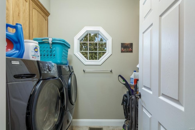 laundry area featuring separate washer and dryer and cabinets