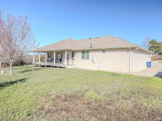 rear view of house featuring a lawn