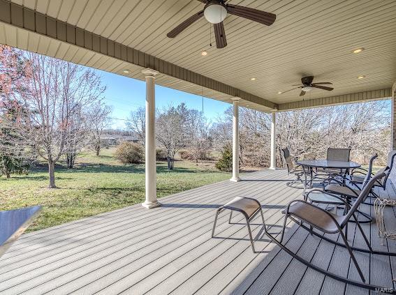 wooden deck with ceiling fan and a yard