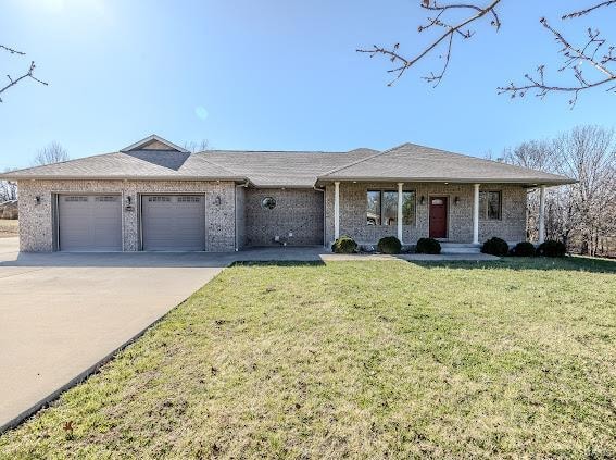 ranch-style house featuring a garage and a front lawn