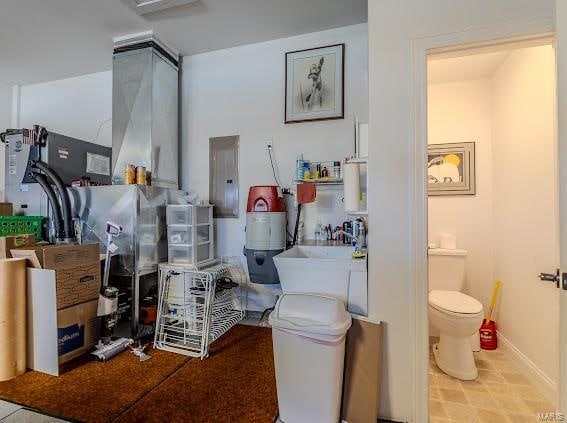 bathroom featuring sink, electric panel, and toilet