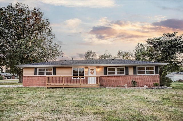 single story home featuring a wooden deck and a yard