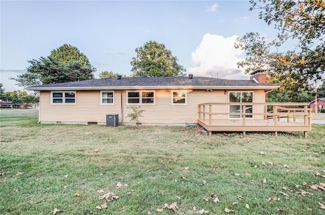 rear view of property featuring a lawn, central AC unit, and a deck