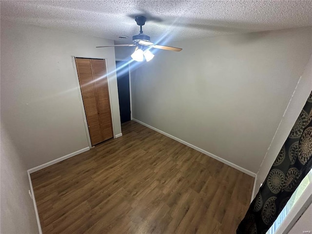 unfurnished bedroom featuring ceiling fan, hardwood / wood-style flooring, a closet, and a textured ceiling