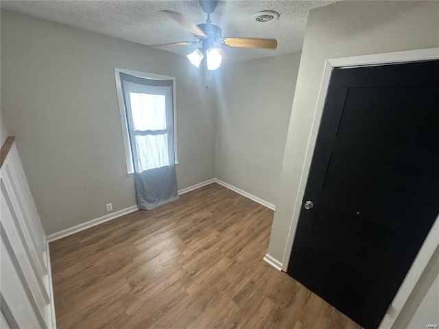 unfurnished room with ceiling fan, a textured ceiling, and hardwood / wood-style floors