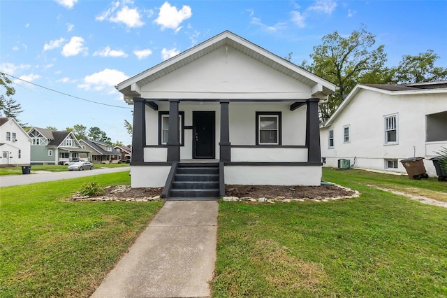 bungalow-style home featuring central air condition unit, covered porch, and a front yard