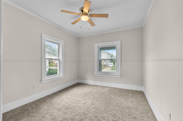 carpeted spare room featuring crown molding and ceiling fan