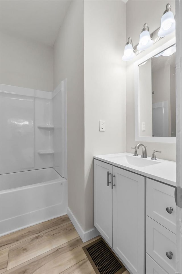 bathroom with shower / bathing tub combination, vanity, and hardwood / wood-style floors