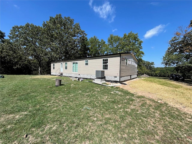 back of house featuring a yard and central AC unit