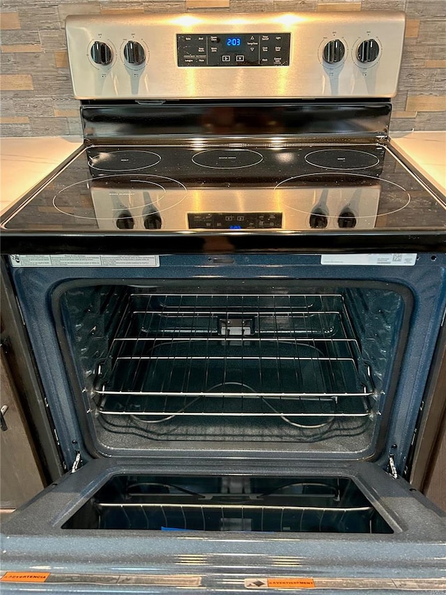 details with backsplash and stainless steel electric range oven