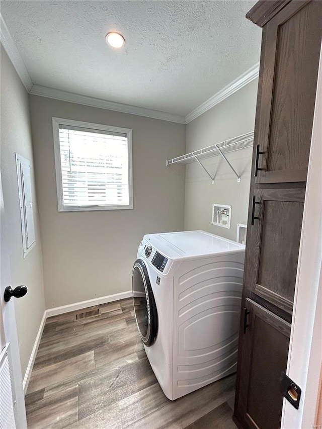 laundry area featuring cabinets, a textured ceiling, hardwood / wood-style flooring, separate washer and dryer, and ornamental molding