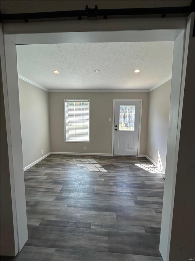 spare room featuring ornamental molding, plenty of natural light, and dark wood-type flooring