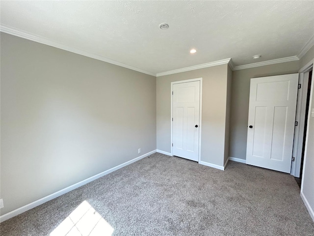 unfurnished bedroom featuring a textured ceiling, crown molding, carpet flooring, and a closet