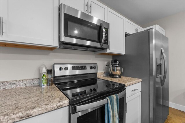 kitchen featuring stainless steel appliances and white cabinets