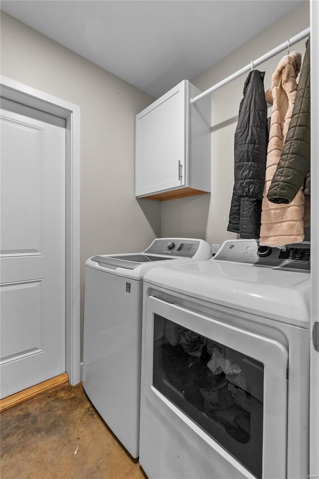 washroom with washing machine and dryer and cabinets