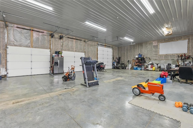 garage featuring stainless steel fridge with ice dispenser