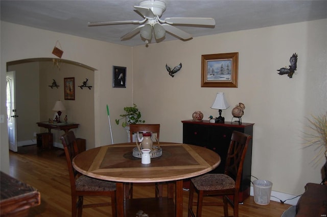 dining space with ceiling fan and wood-type flooring