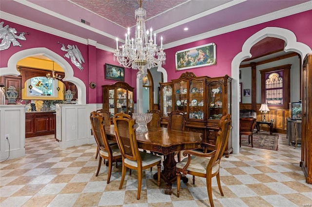 dining area with crown molding and an inviting chandelier