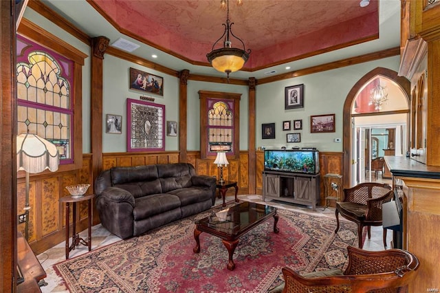 living room featuring a raised ceiling and crown molding