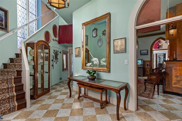 foyer with a healthy amount of sunlight, a towering ceiling, and a chandelier