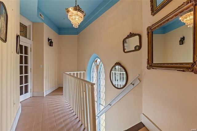 corridor with an inviting chandelier and parquet flooring