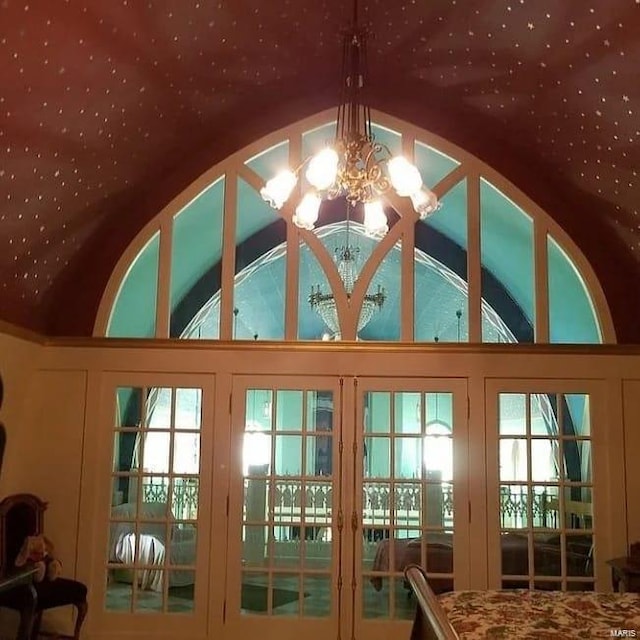 doorway featuring a notable chandelier and lofted ceiling