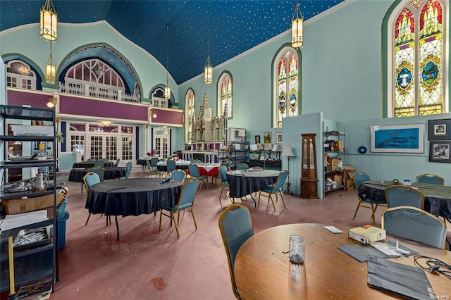 dining space with carpet flooring and high vaulted ceiling