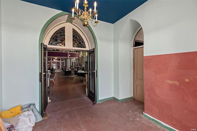 hall with an inviting chandelier and high vaulted ceiling