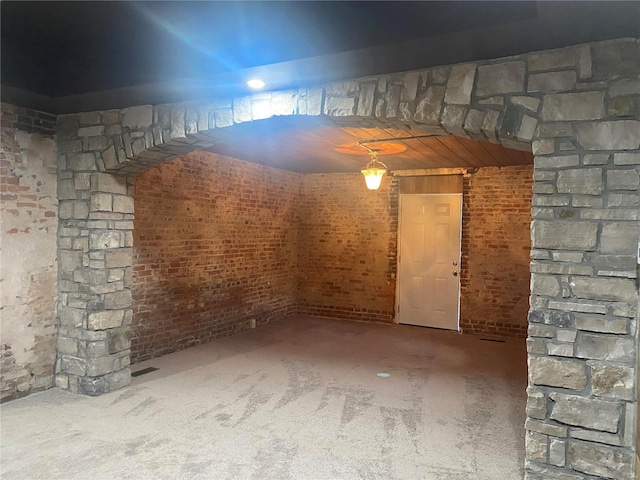 basement with carpet and brick wall