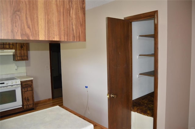 kitchen with a textured ceiling, light wood-type flooring, and white stove