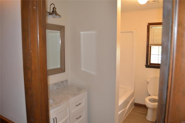 bathroom featuring wood-type flooring, vanity, and toilet