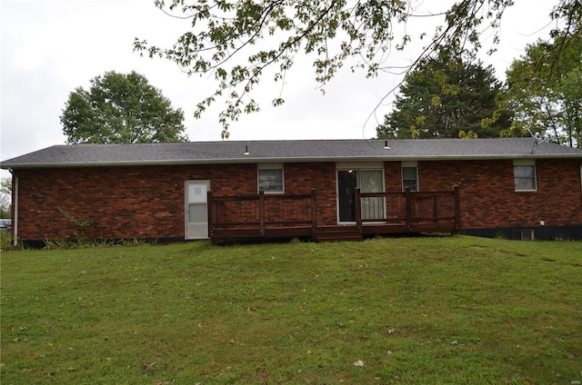 back of house featuring a wooden deck and a yard