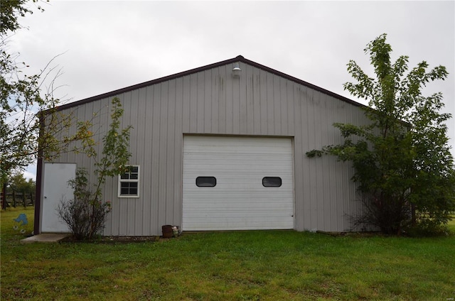 garage with a lawn and wood walls