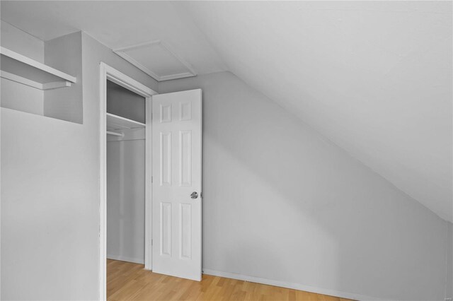 bonus room featuring vaulted ceiling and hardwood / wood-style floors