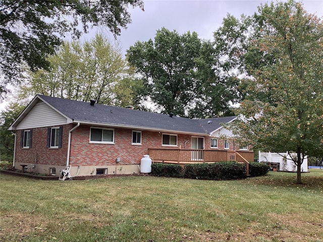 back of property with a deck and a lawn