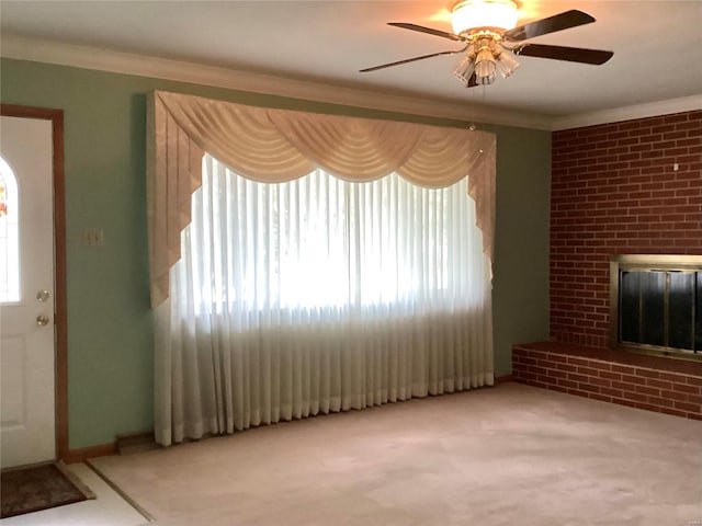 unfurnished living room with light carpet, crown molding, a fireplace, and ceiling fan