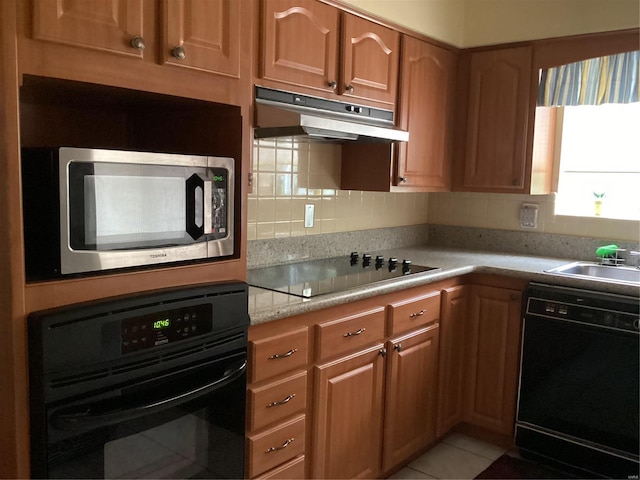 kitchen with light tile patterned flooring, black appliances, sink, and backsplash