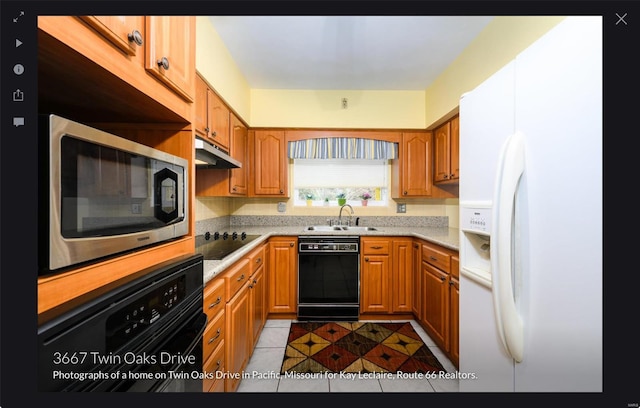 kitchen featuring light tile patterned flooring, black appliances, and sink